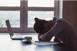 young woman sleeping at desk