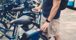 Man standing by bikes with smartphone