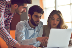 three colleagues looking at laptop ransomware