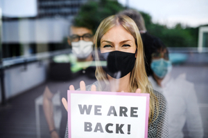 masked woman with open sign