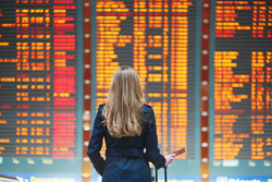 female traveller at airport departure board